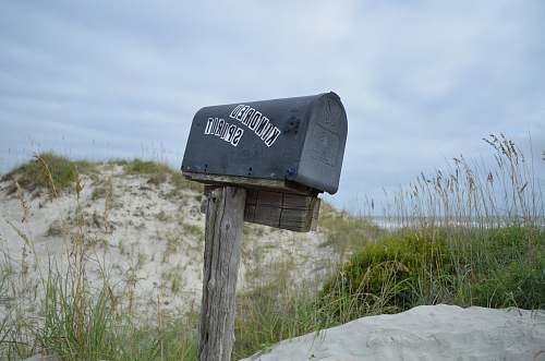sign shallow focus photography of mailbox surrounded by grass street sign